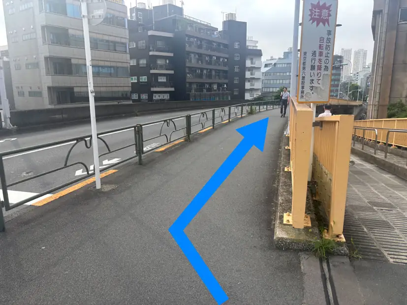 矢印の方向に下るゆるやかな坂道